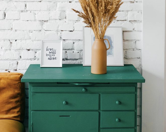 A green drawer stands against the white wall