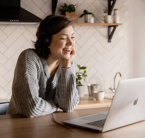 A woman sits at the table and chats over the video call